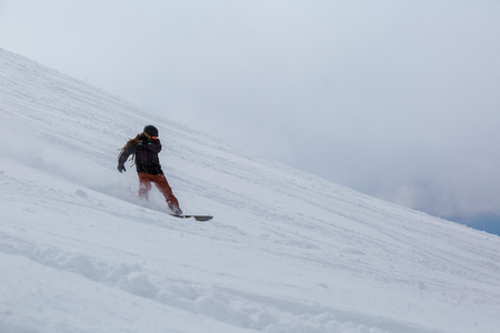 男性的滑雪板滑雪上新鲜的雪
