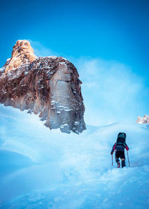 背着背包徒步旅行者到达山峰的峰会。成功 自由和幸福，在山中的成就。活跃的运动概念