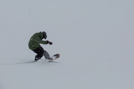 男性的滑雪板上新鲜的雪滑雪斜坡上滑雪