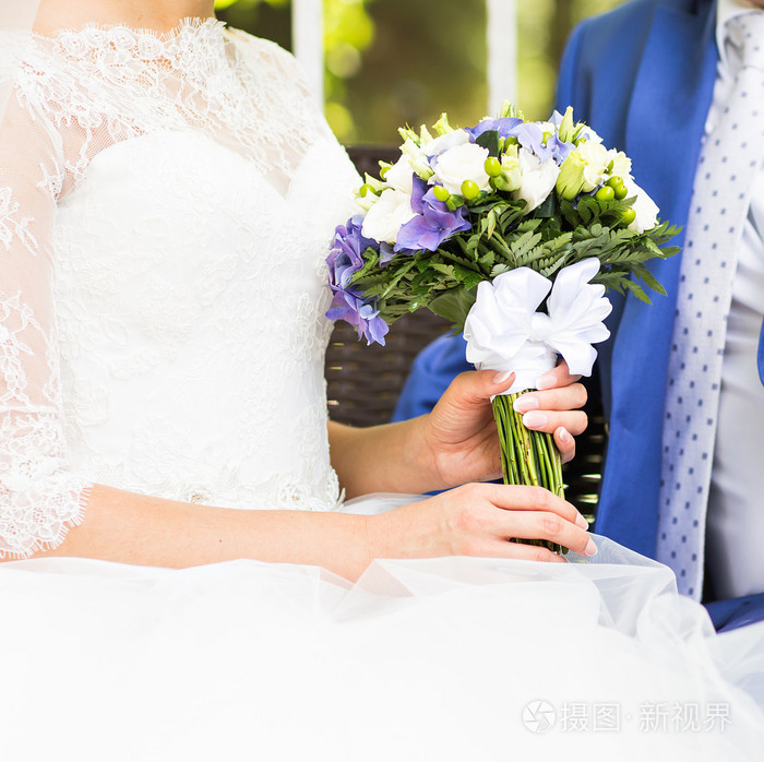 在手中的新娘特写的美丽婚礼花束