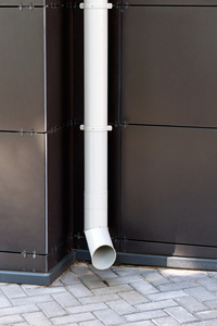 在现代建筑立面上的白色排水管照片