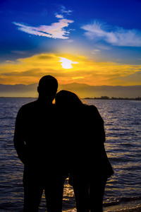 恋人在海岸日落两个恋人在日落时的剪影照片