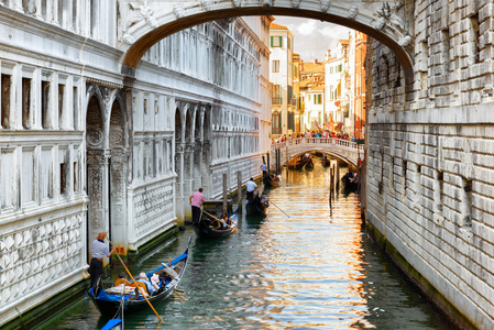在威尼斯叹息桥下航行的贡多拉斯游客