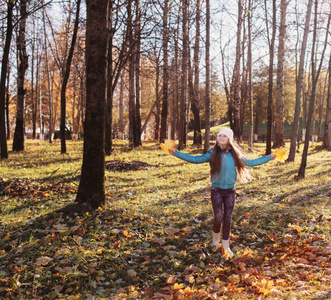 快乐的女孩与秋天的树叶