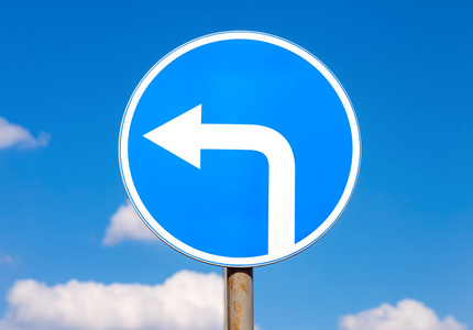 路标左转在蓝色的天空挪威的强制性方向标志-向左转禁止车辆左转的