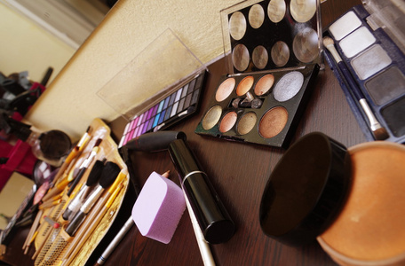 不同的化妆工具在桌子上准备使用特写