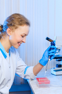手里的吸管的女科学家化学家在现代实验室中进行了分析