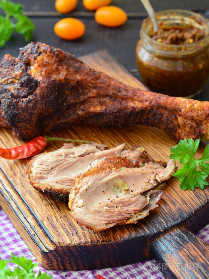 在一个黑暗的木桌上烤火鸡鸡腿