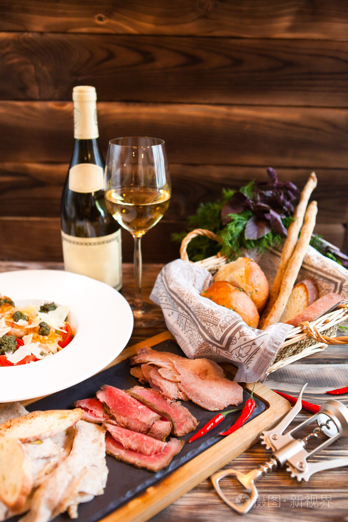 白葡萄酒的小吃被沙拉在餐厅的桌子上