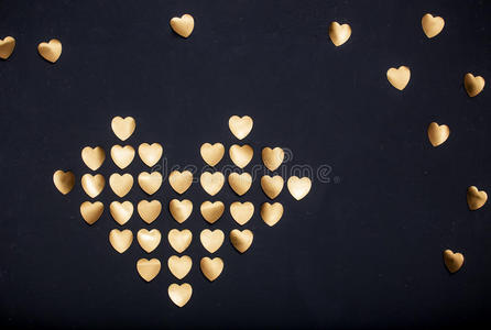 金色的心是由黑暗背景上的贴纸制成的