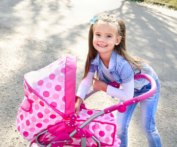 可爱的微笑小女孩玩她的玩具马车