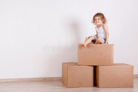 孩子坐在盒子上的房间里。