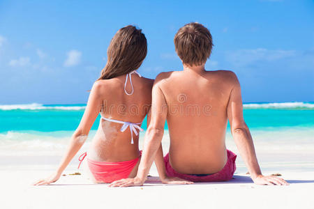 一对夫妇坐在热带海滩上的背景