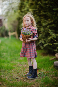 春天花园里带着一篮子蓝铃的可爱女孩