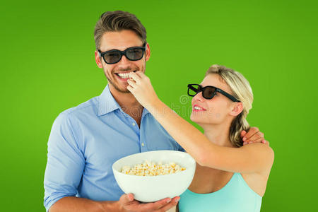 幸福的年轻夫妇戴着3D眼镜吃爆米花的复合图像