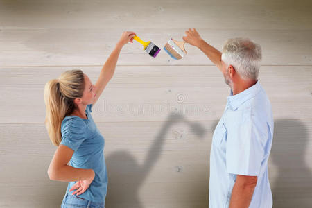 幸福夫妇用画笔画墙的复合图像