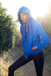 女性健身模特在户外穿着蓝色运动衫
