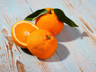 大的成熟橙色水果，叶子在木制背景上
