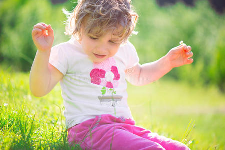 阳光明媚的草地上可爱的小女孩