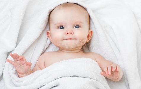 可爱有趣的微笑宝宝躺在后面洗澡