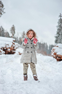 女孩在冬天的雪林里散步