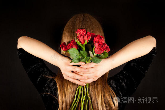 一个年轻漂亮的女人带着红玫瑰