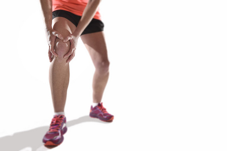 年轻的运动女人强运动腿抱着膝盖与双手在痛苦受难韧带损伤