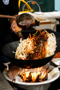 街头食品。在锅中用鸡肉，虾炒面