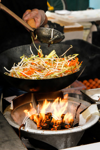 街头食品。在锅中用鸡肉，虾炒面