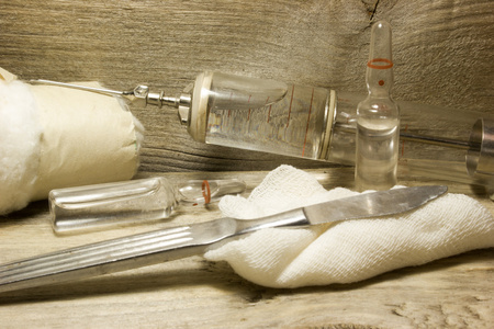 老式注射器用针在一个木制的背景上铁老式玻璃注射器照片