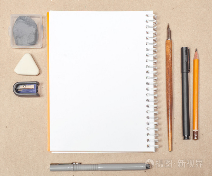 空白的素描本页面的钢笔和工艺报上的橡皮擦