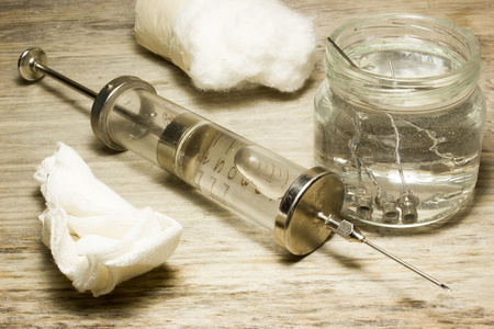 用针在一个木制的背景上铁老式玻璃注射器照片
