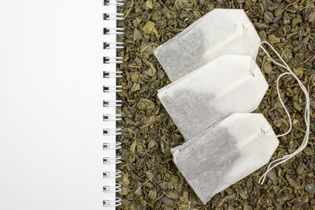 干燥的绿茶，一张空白的纸，茶叶袋