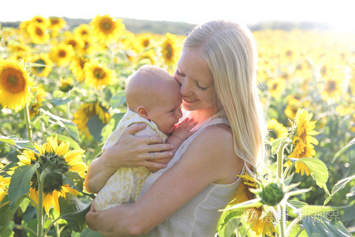 快乐的妈妈，在花草甸中拥抱的宝贝女儿