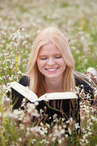 年轻女子在草地上看书