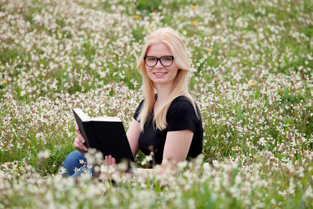 年轻女子在草地上看书