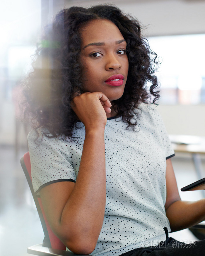 自信的女性设计师工作在数字平板电脑上的红色创意办公空间