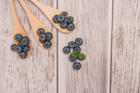用木勺和质朴的文字上薄荷叶新鲜蓝莓