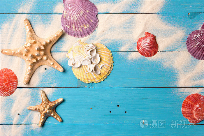 海洋夏日明信片。在蓝色的木板上，在沙滩上的贝壳