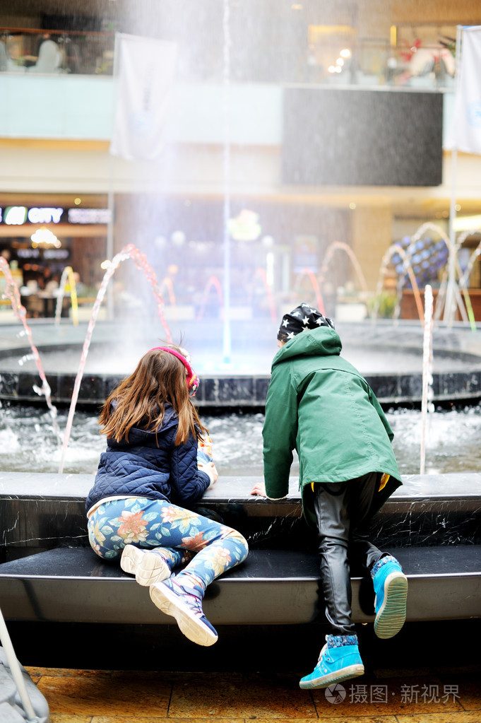 两个可爱的小女孩玩城市喷泉