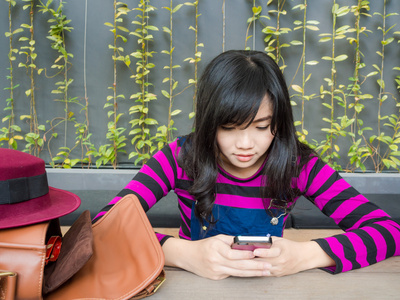 年轻的亚裔女子，在使用 telephonephone 的咖啡馆