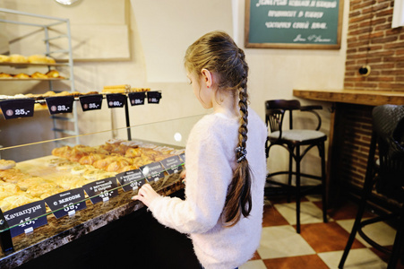 小女孩在一家食品店选择面包图片