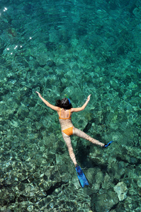 年轻女子在透明的浅海浮潜