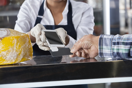 接受付款交单从客户奶酪店里的售货员照片