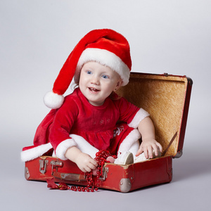 可爱的小女孩带着圣诞小提箱
