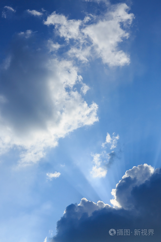 新光的阳光透过云层上湛蓝的天空