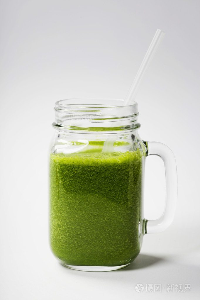 健康的绿色果汁用稻草放在罐子里杯子里