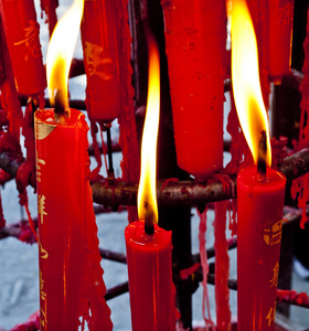 复制空间佛教徒在寺庙的佛坛上点燃一支点燃的蜡烛,用蜡烛框架点燃