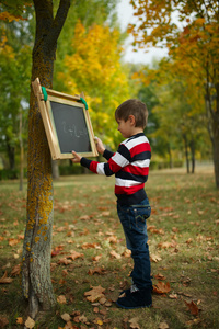 在黑板上写字的小快乐男孩
