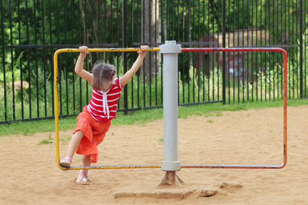 快乐的小女孩,穿着短裙的旋转上回旋儿童游戏照片